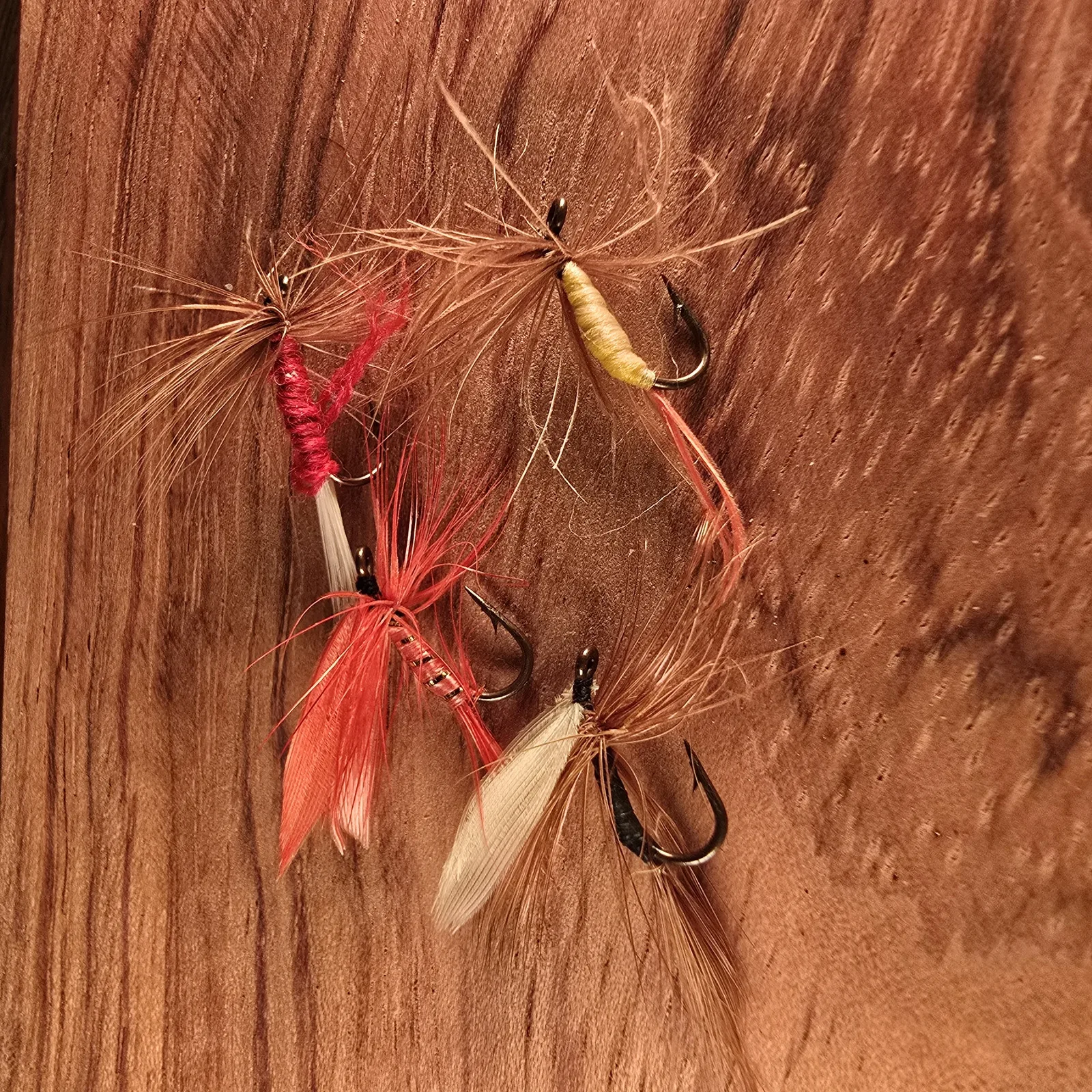 Hand-tied soft-hackle wet flies on warm wood